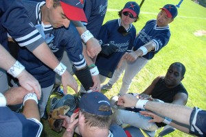 The Renegades huddle before a game as many of the players wear a wrist band with the initials "BW" in honor of Coach Rob's father who was battling brain cancer