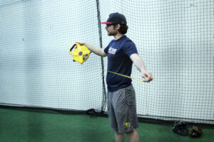 Teiagn stretches out a tape measure to mark the distance to home plate for his BP session in the cage in May
