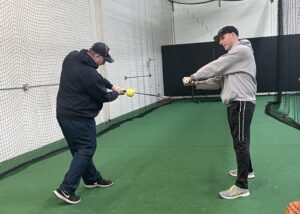 Ron works with Sahwn on his hand path in the batting cage