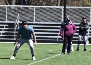 Gina syands behind Shayne Cantan calling defensive drills on the turd