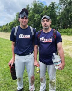 Shawn and Rob pose for a photo without smiles and their blindfolds on their foreheads, each holding jugs of hyrdation