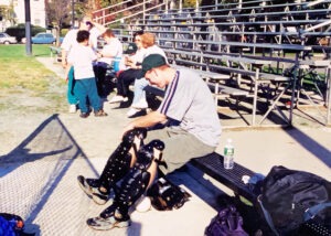Ron Cochran straps on shin guards to prepare to pitch in 2000